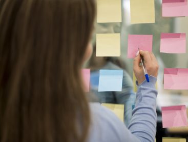 Fotografía de mujer escribiendo un post it